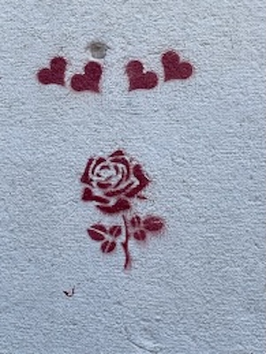 Herzen und ein Rose an einer Wand