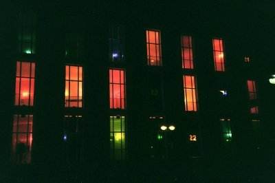 Haus im Dunkeln mit verschieden beleuchteten Fenstern
