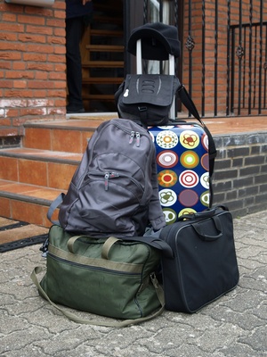 Koffer und Taschen vor einem Haus