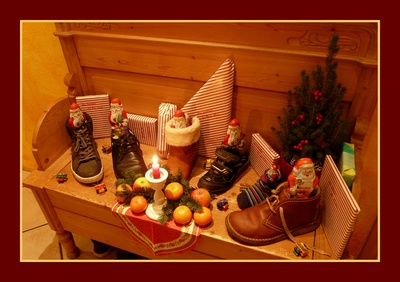 Stiefel und Schuhe auf einer Bank mit Nikoläusen