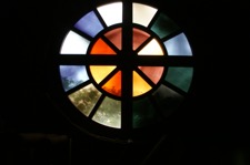 Rundes Fenster mit Farbsegmenten und Kreuz