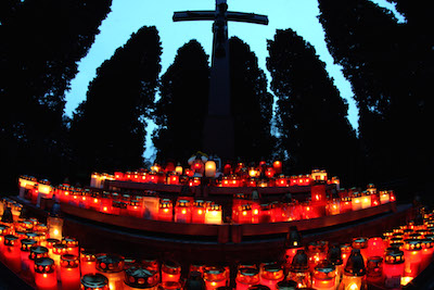 Viele Grablichter an einem Grab