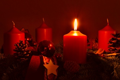 Adventskranz mit einer brennenden Kerze