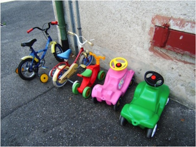 Parkende Kinderfahrraeder und Bobbycars