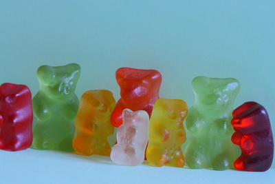 Reihe verschieden farbiger und grosser Gummibaeren