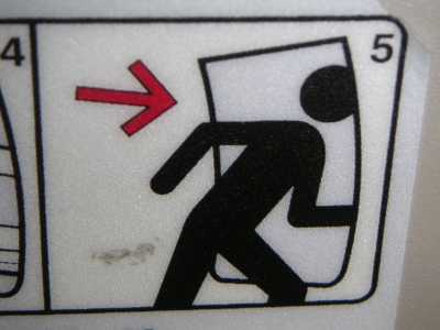 Fluchtwegschild-Person geht durch eine Tuer