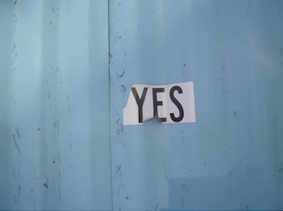 Türkise Wand mit einem weissen Zettel mit dem Wort YES