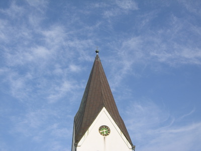 Kirchturm vor Sommerwolken