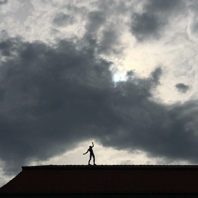 Balancierender Mensch auf dem Dach