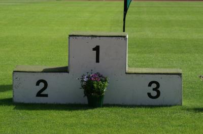 Leerer Siegerpodest mit buntem Blumentopf unter der 1