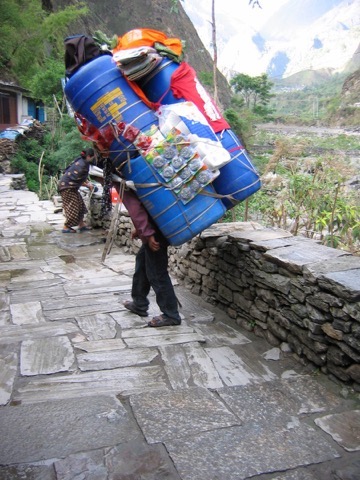 Mensch mit viel Gepäck auf dem Rücken