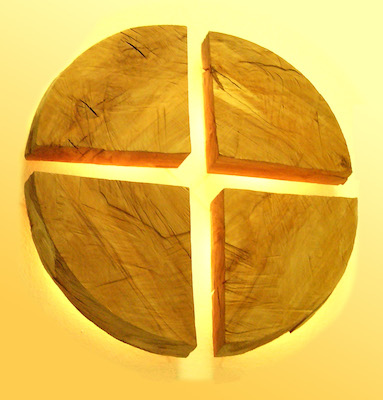 Kreuz aus vier Holz-Kreissegmenten im Gegenlicht