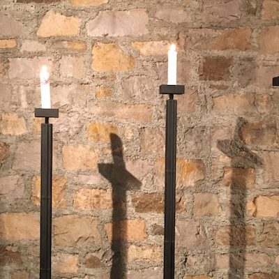 2 brennende Altarlkerzen mit Kreuz-Schatten 2 brennende Altarlkerzen mit Kreuz-Schatten