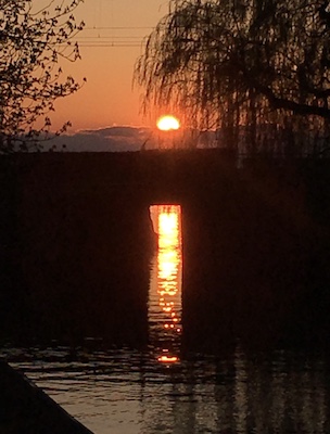 Sonnenuntergang an einer Eisenbahnbrücke mit Spiegelung im Wasser