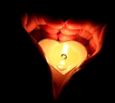 Herzenskerze von Händen umschlossen