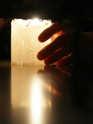 Nahaufnahme Kerze mit umschliessender Hand Nahaufnahme Kerze mit umschliessender Hand