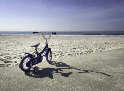 Kinderfahrrad an weitem Strand