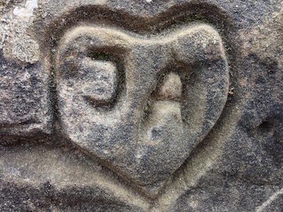 Das Wort Ja mit Herz umrandet in Stein geritzt