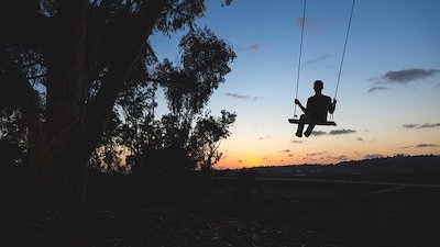 Schaukelnde Person im Sonnenuntergang Schaukelnde Person im Sonnenuntergang