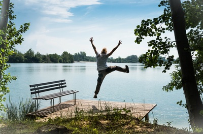 Freudensprung einer Person an einem See