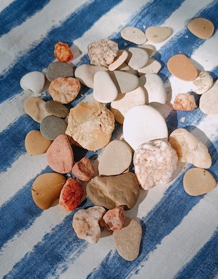 Steine auf einer blau-weiß gestreiften Decke Steine auf einer blau-weiß gestreiften Decke