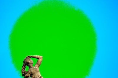 Kopf einer Frauenstatue schaut nach oben in eine grüne Sonne Kopf einer Frauenstatue schaut nach oben in eine grüne Sonne