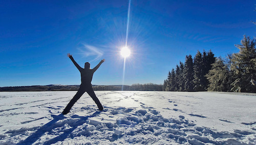 Armeaustreckende Person im Schnee