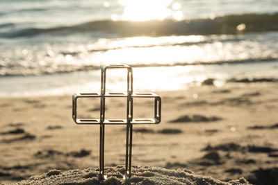 Metallkreuz am Strand