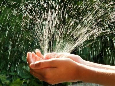 In Hände spritzt frisches Wasser