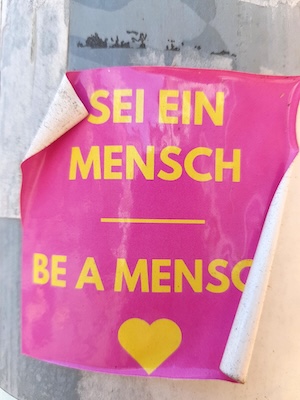 Plakat mit der Aufschrift: Sei ein Mensch